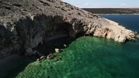 Toma-Aérea-Frente-A-La-Costa-De-Koromacno-En-Croacia-Con-Un-Mar-Cristalino-Y-Una-Playa-De-Montañas-Rocosas-4k