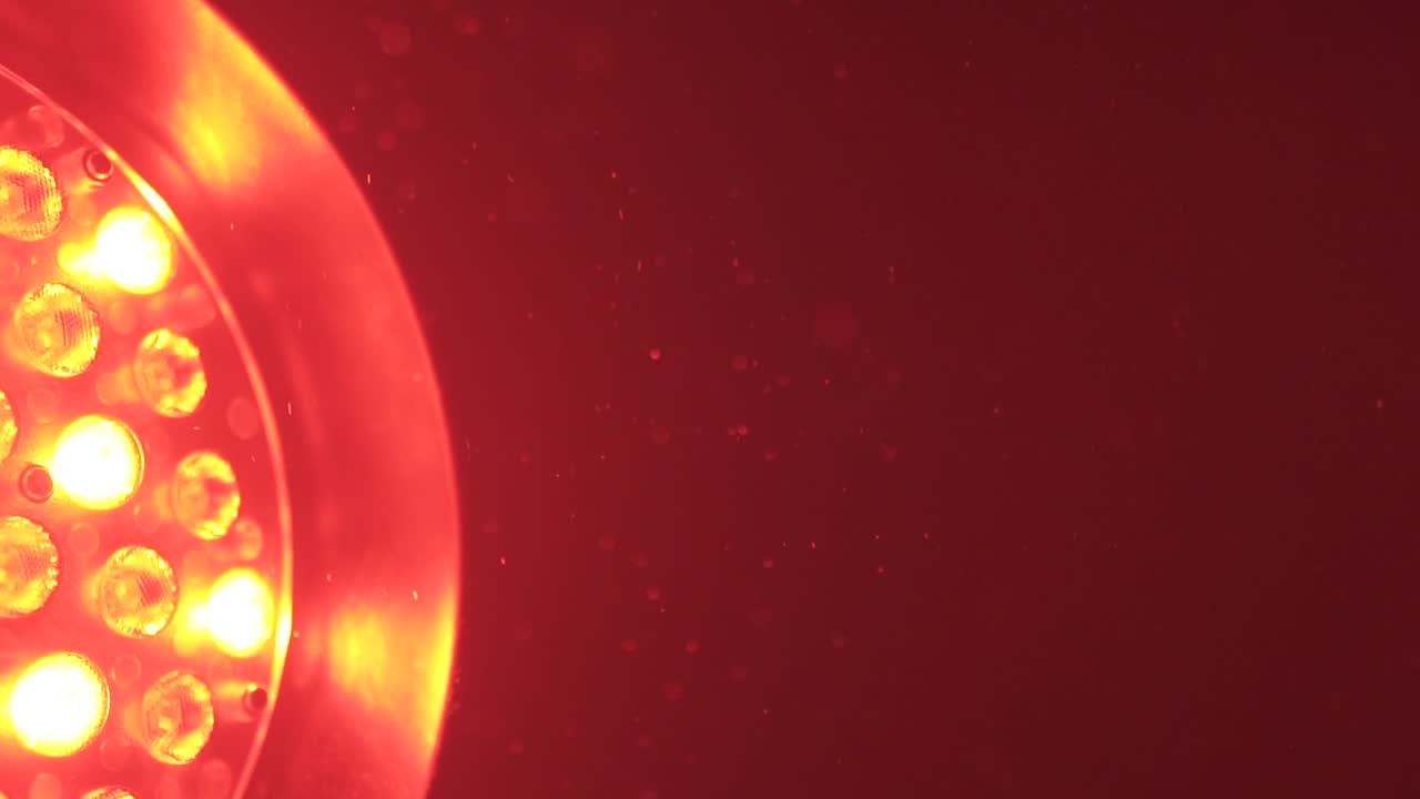 Red industrial entertainment light revealing small dust particles floating through the sky.