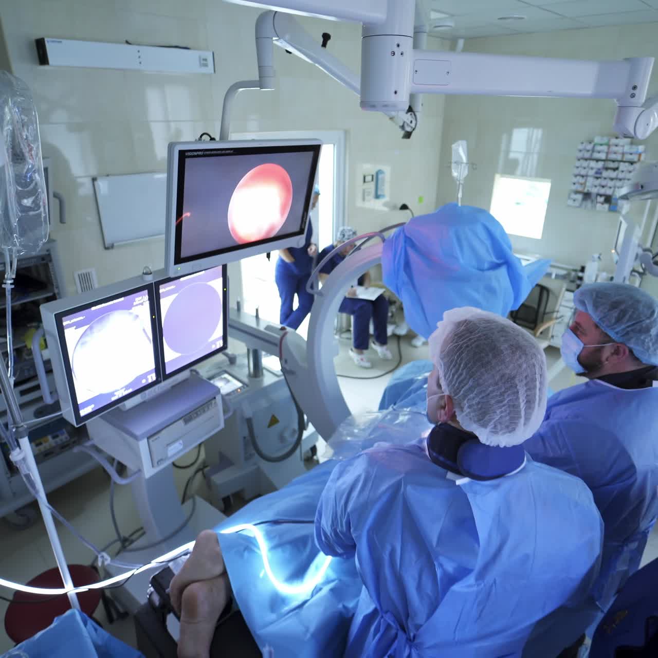 Operating ward full of surgeons. Handsome doctor surgeon working with team