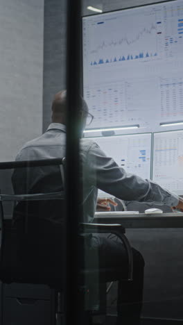 financial analyst suffering from financial crisis, yelling in phone, analyzing exchange market charts in office. african american businessman furious about stock market collapse. vertical shot.