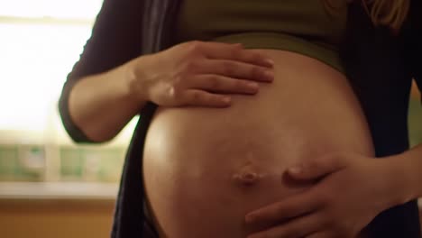 intimate moments captured: a close-up view of a pregnant woman's belly, signifying the journey of motherhood and new life in a warm domestic atmosphere