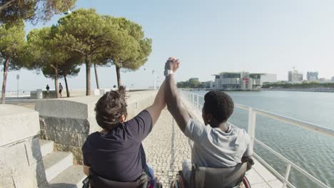 rear view of happy couple with disability raising arms together