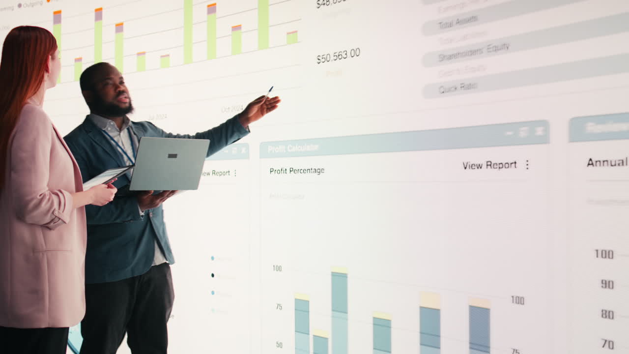 Business Professionals Discussing Financial Data on Large Digital Screen