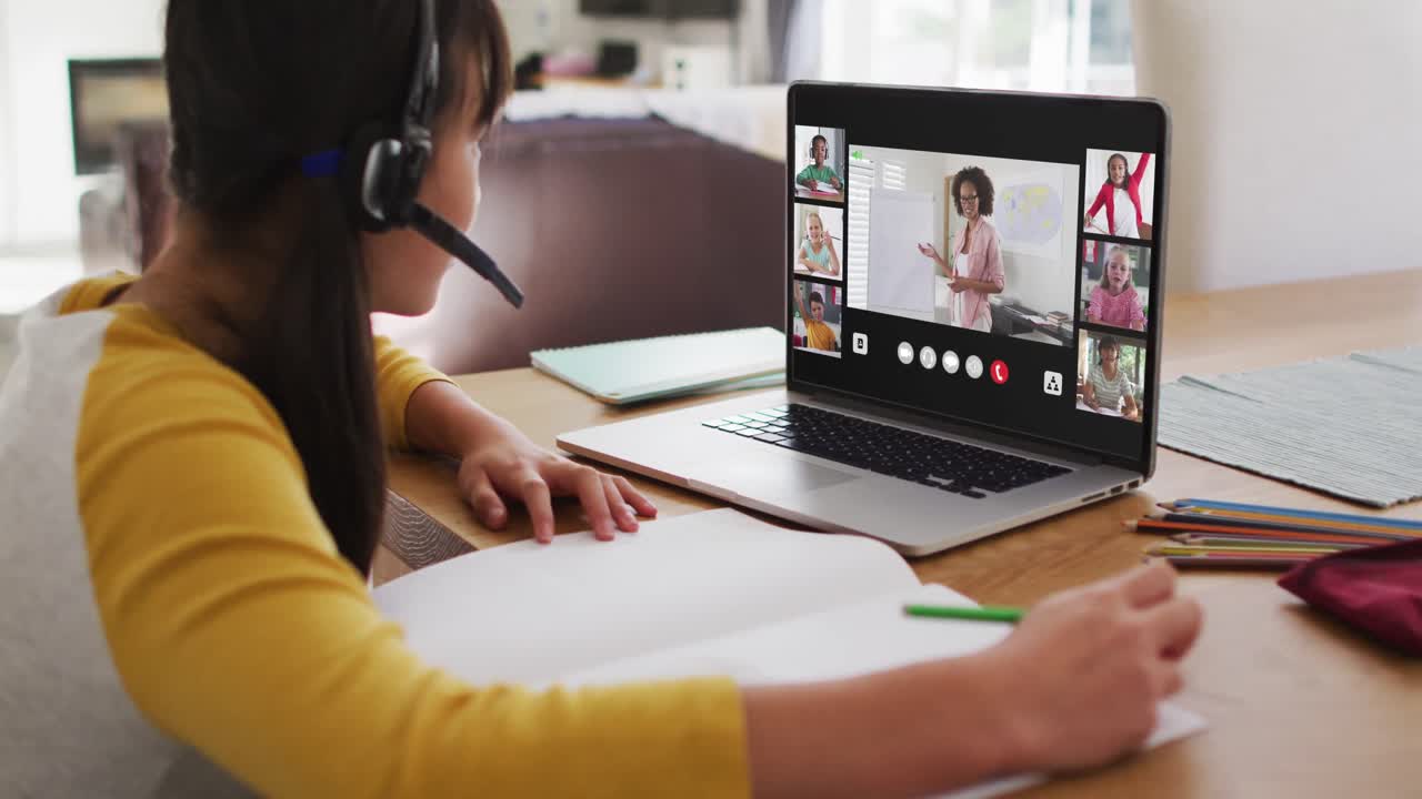 Schoolgirl using laptop for online lesson at home, with diverse teacher and class on screen