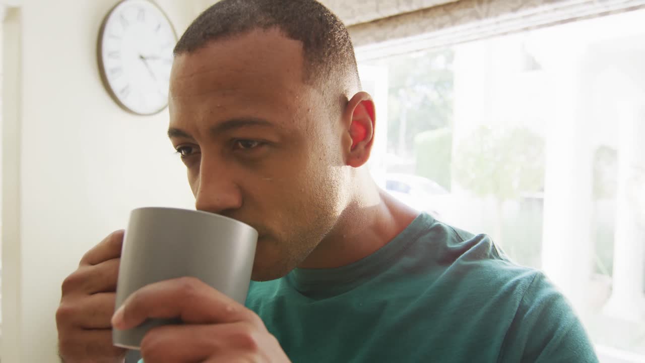 주방 에서 커피 를 마시는 사려 깊은 두 인종 의 남자 의 초상화