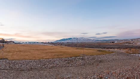 Morning-dawns-over-a-grassy-field-in-a-suburban-neighborhood---colorful-cloudscape-time-lapse