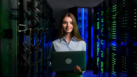 woman working in a data center with a laptop