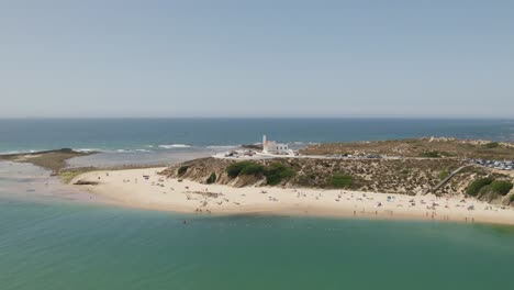 aerial view around the lighthouse in vila nova de milfontes, sunny portugal - orbit, drone shot