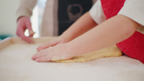 niño forma la masa en la cocina preparándose para hornear galletas de pan de jengibre