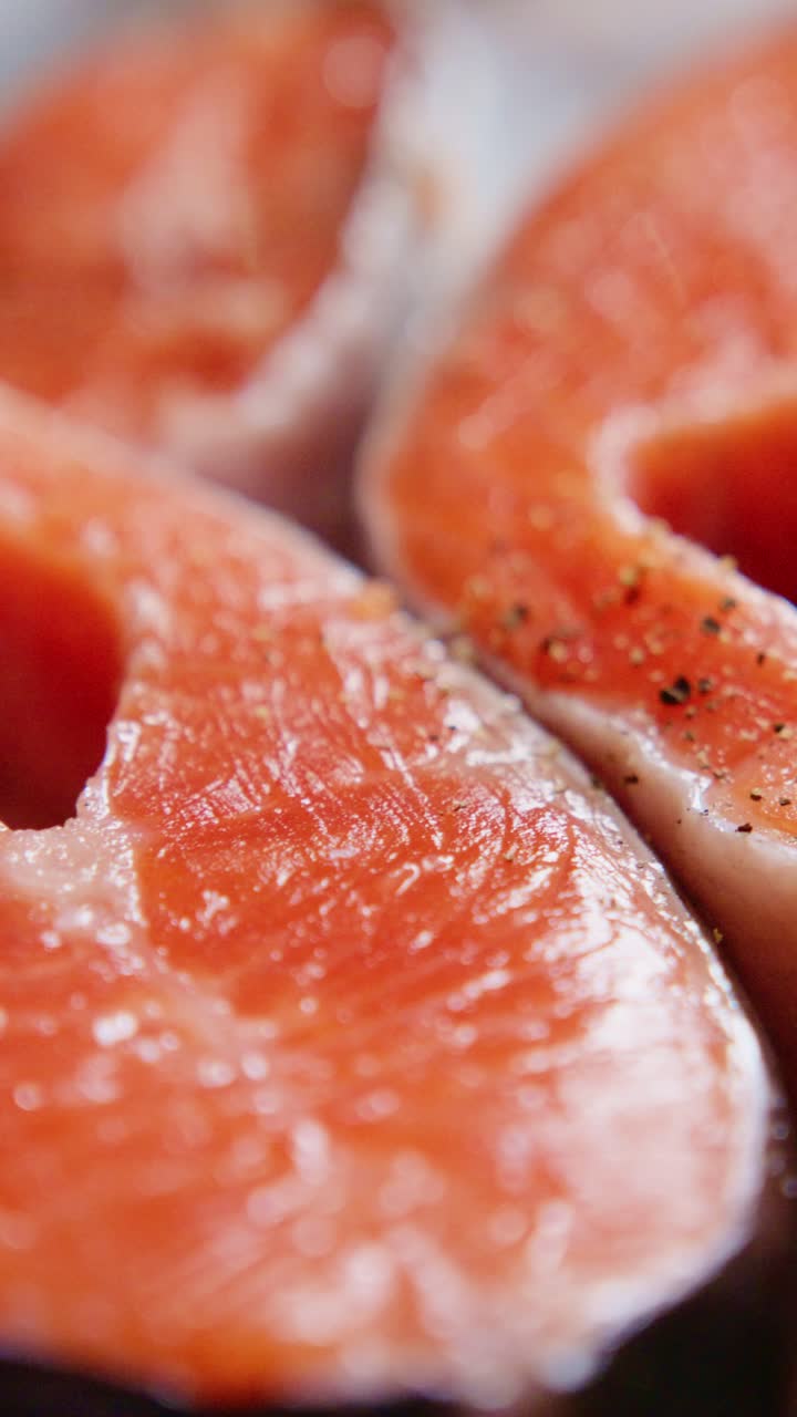 Primi piani di filetti di salmone fresco che mettono in risalto il colore e la consistenza intensi, perfetti per essere grigliati o cotti al forno, migliorando l'esperienza culinaria con una preparazione di piatti saporiti