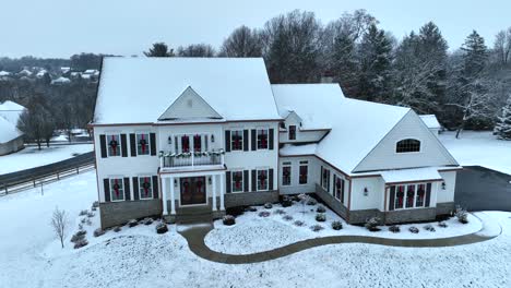 snow covered house with holiday christmas wreaths and decor