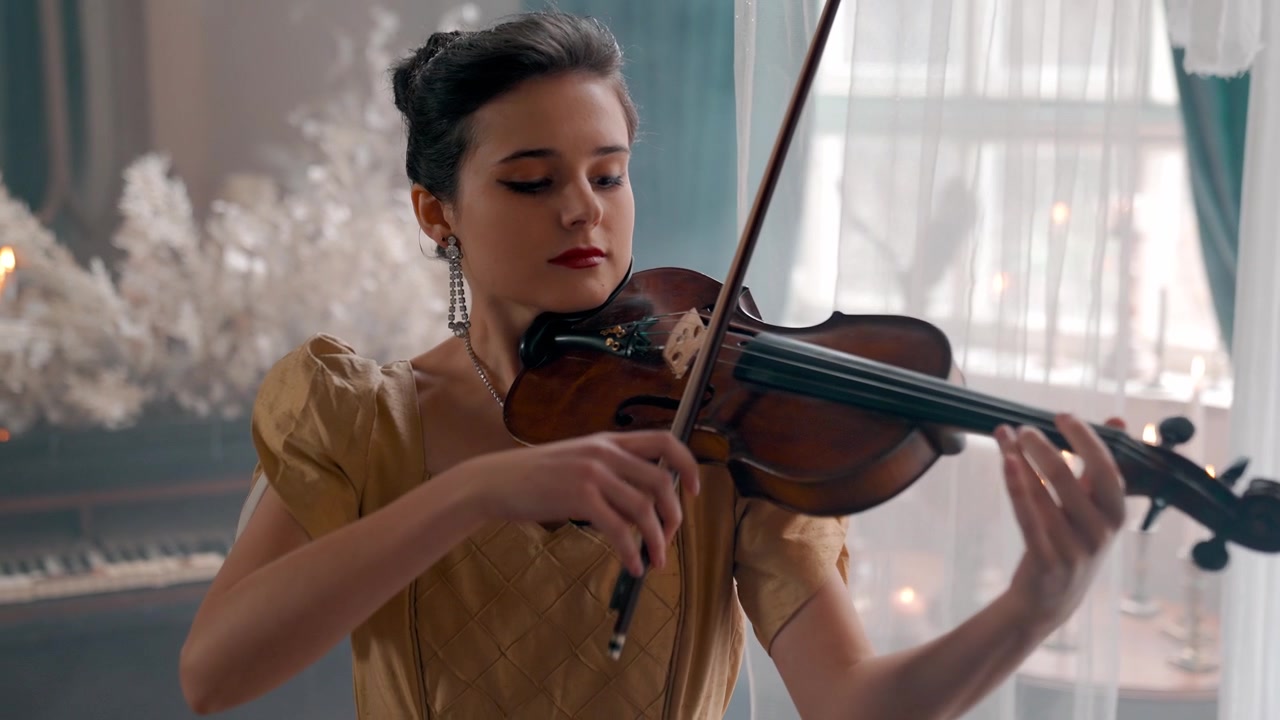 Giovane donna elegante che suona il violino in un ambiente classico