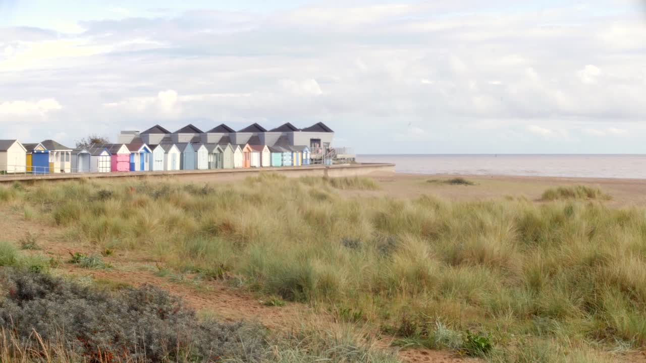 una gaviota vuela más allá de las cabañas de playa y el observatorio del mar del norte en el punto de la capilla en la costa este de inglaterra cerca de skegness