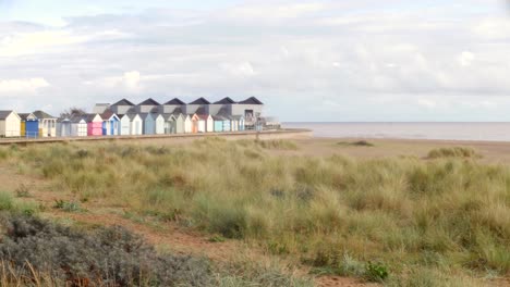 Eine-Möwe-Fliegt-An-Den-Strandhütten-Und-Dem-Nordsee-Observatorium-Am-Chapel-Point-An-Der-Ostküste-Englands-In-Der-Nähe-Von-Skegness-Vorbei