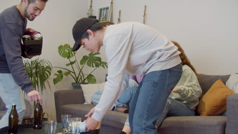 남자들이 음식과 음료를 가져오고 여성들이 집에서 소파에 앉아 있습니다.