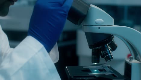 científico usando el microscopio en un laboratorio