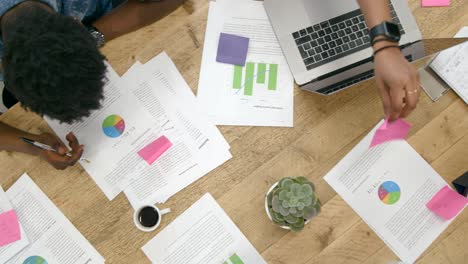 Overhead-View-Male-And-Female-Colleagues-Working-Together-At-Table