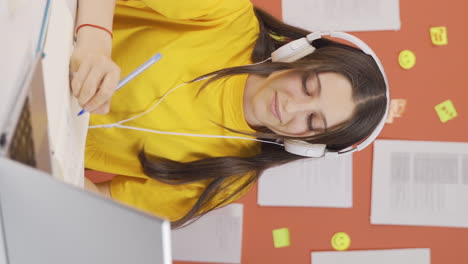 video vertical de una niña escuchando música con auriculares en casa