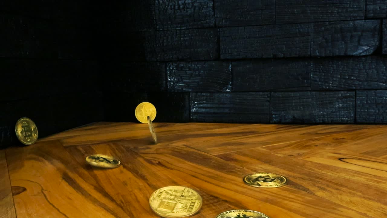 Bitcoin golden and shiny cryptocurrency or crypto money coins falling on an olive wood kitchen table countertop in slow motion while a Yakisugi burned or charcoal design wall panels are in the back
