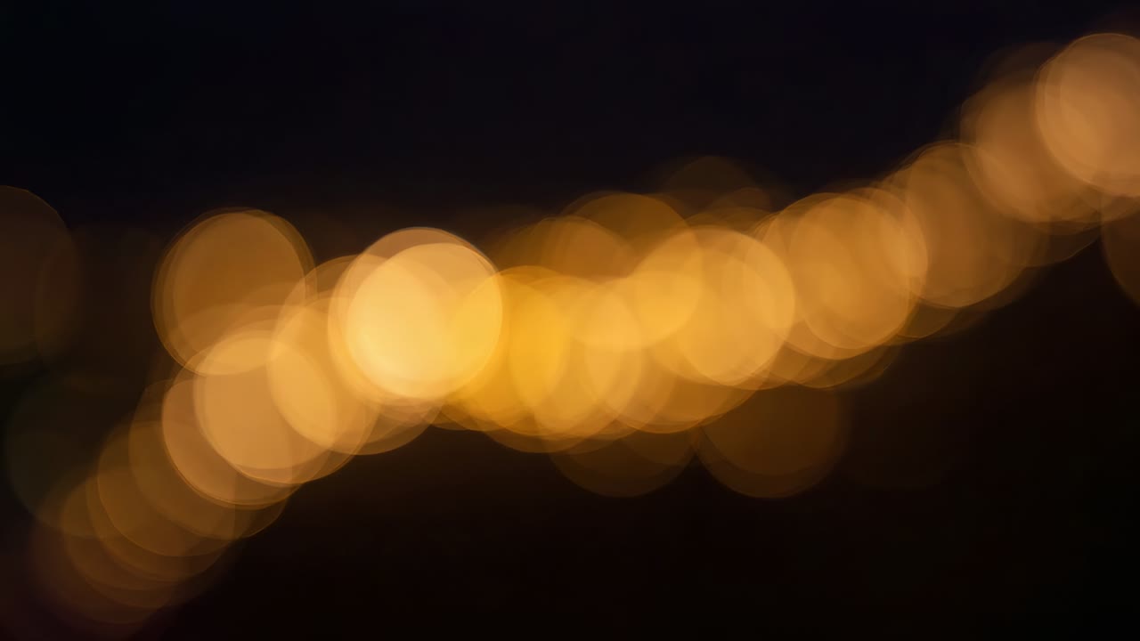 Messa a fuoco selettiva, la telecamera rivela una diagonale di luci calde su un tetto, mostrando lampadine a forma di goccia