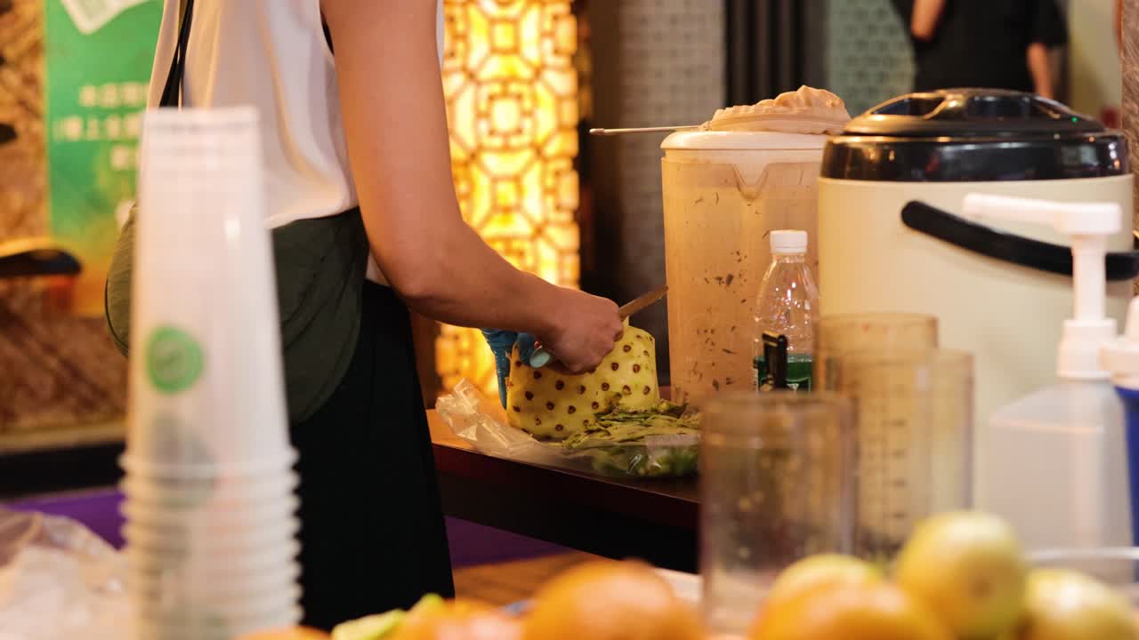 vendedor cortando piña en un puesto de jugo