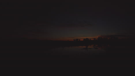 golden hour sunset in california. reflections from a pond in the foreground, the clouds and glow are presented as the sun goes down below the horizon. located in a prairie.
