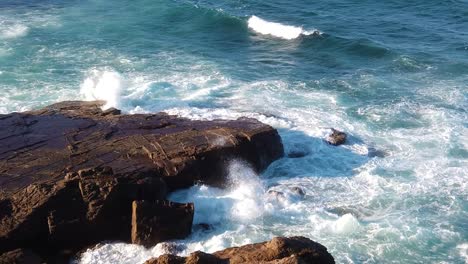 las olas del océano inundan la costa rocosa, mostrando la fuerza extrema del océano