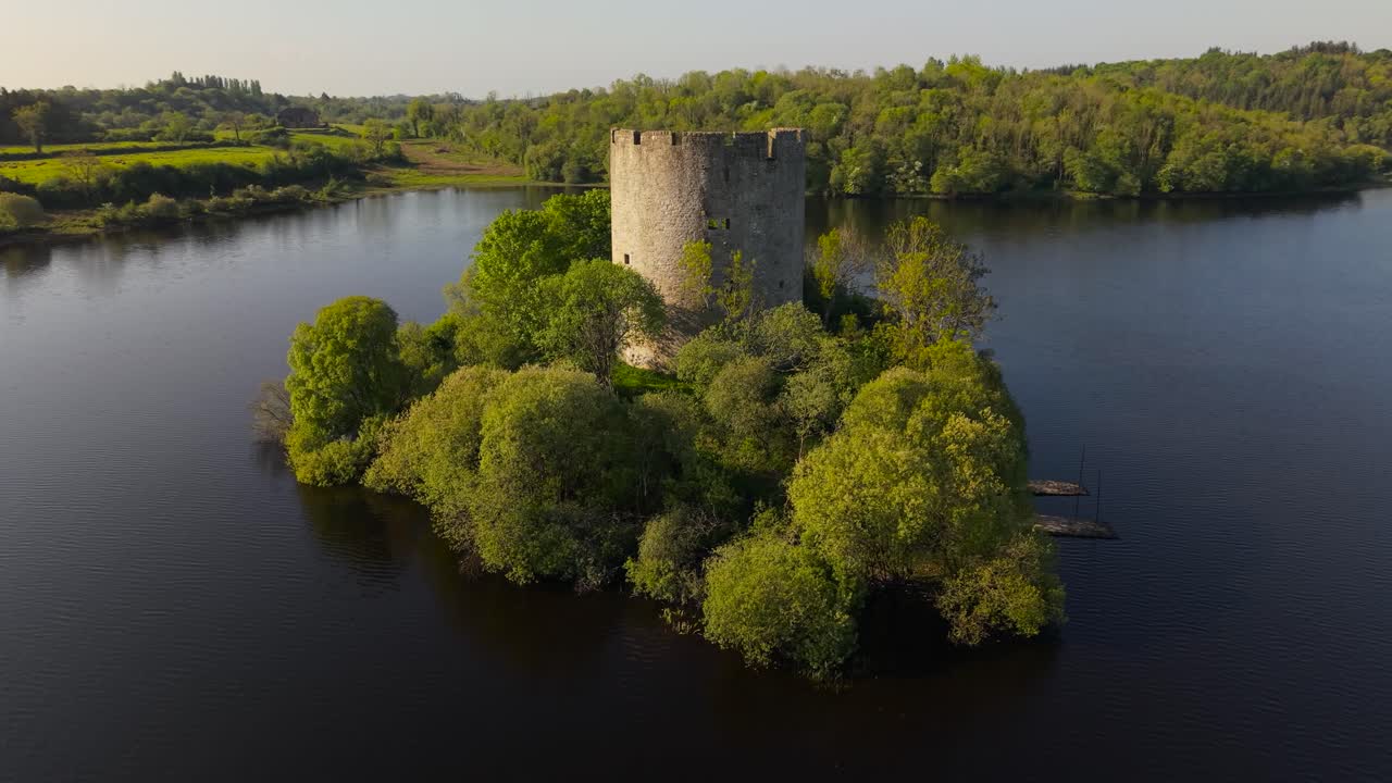 Cloughoughter Castle, a ruined circular fortress, sits on a small island in Lough Oughter, surrounded by lush greenery in County Cavan, Ireland