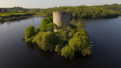 cloughoughter castle, a ruined circular fortress, sits on a small island in lough oughter, surrounded by lush greenery in county cavan, ireland