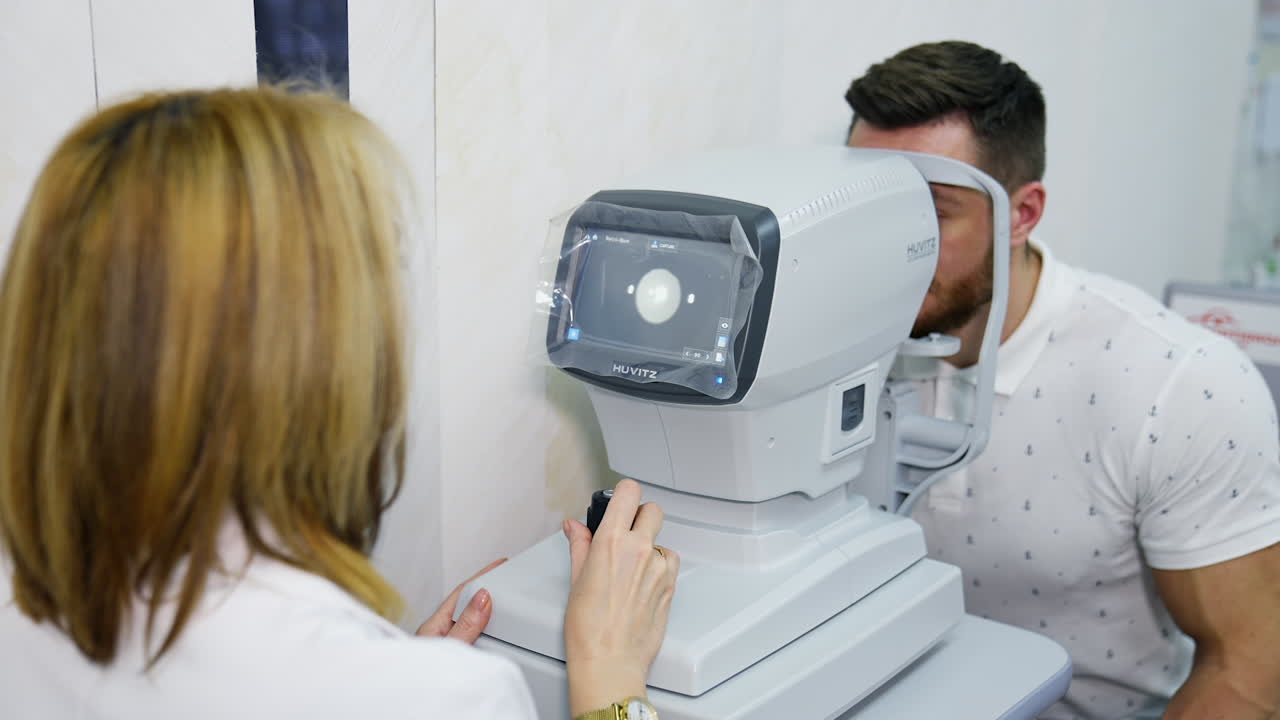 Female optometrist checking patient vision. Ophthalmologist checking eyesight of his patient