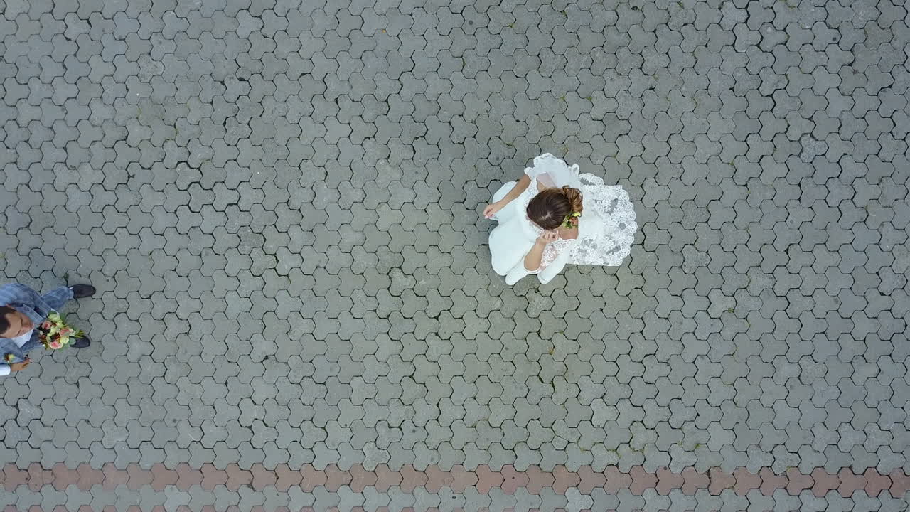 Merry newlyweds toss the bouquet up. Aerial view.