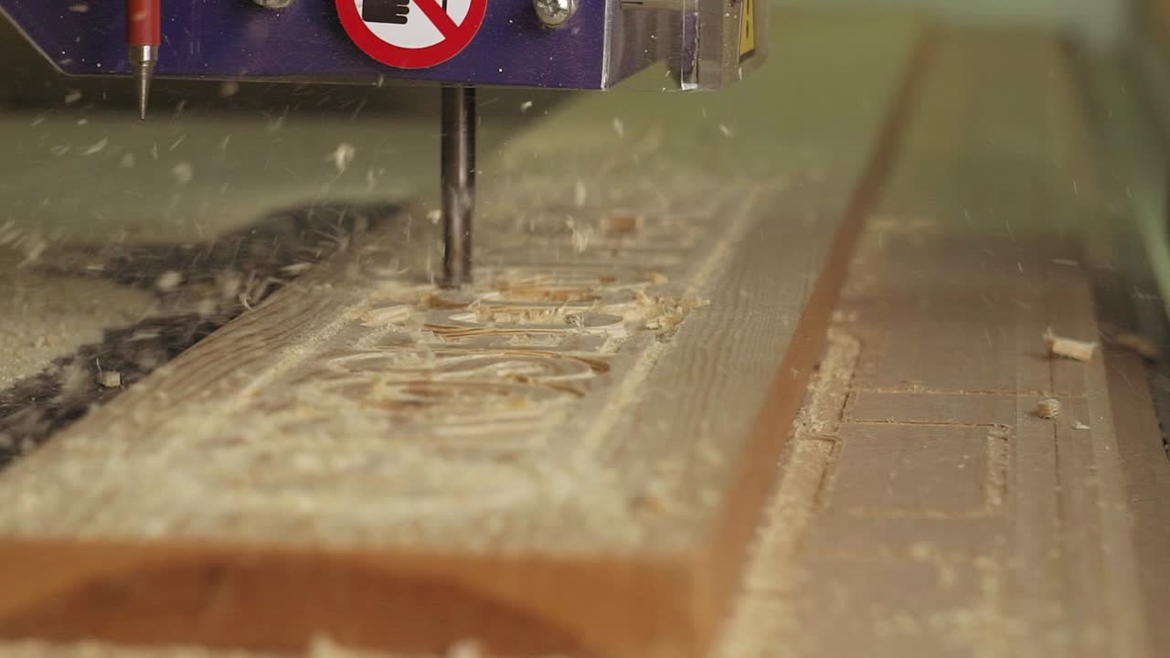 una toma en cámara lenta de una máquina cnc cortando un letrero de madera