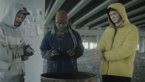 homeless men seeking warmth under a bridge