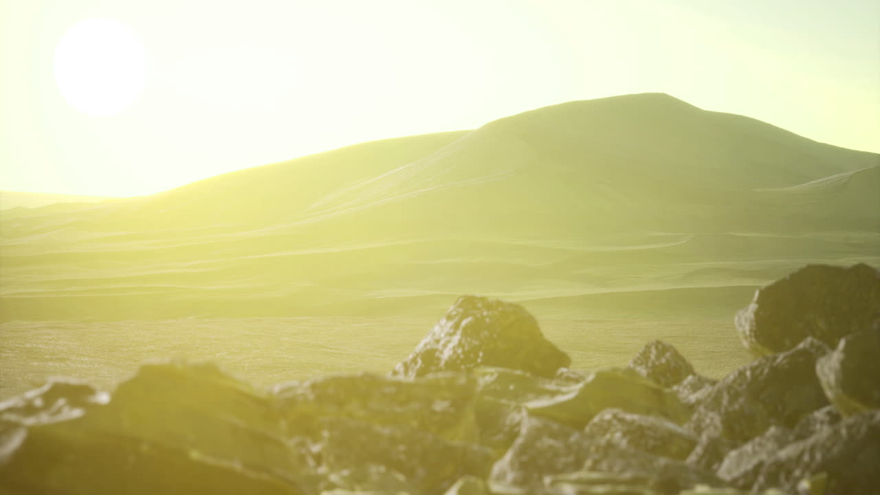 Sunrise over rocky terrain in a vast desert landscape