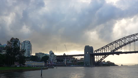 a train passes over sydney harbour bridge in the early morning, australia