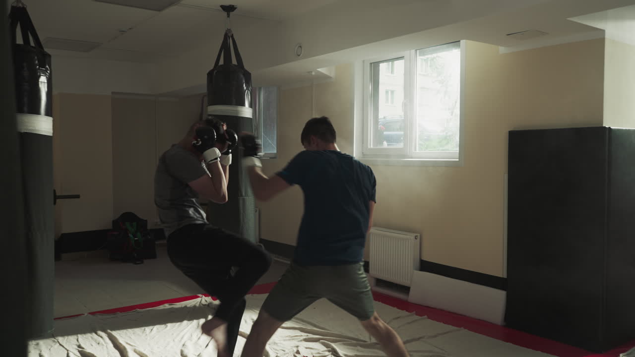 키크박스 선수들은 스포츠 클럽에서 우호적인 스파링에서 싸운다. 젊은 무술 마스터들은 빈 체육관에서 공격과 블록을 연습한다. 스포츠 선수들은 전투 훈련을 한다.