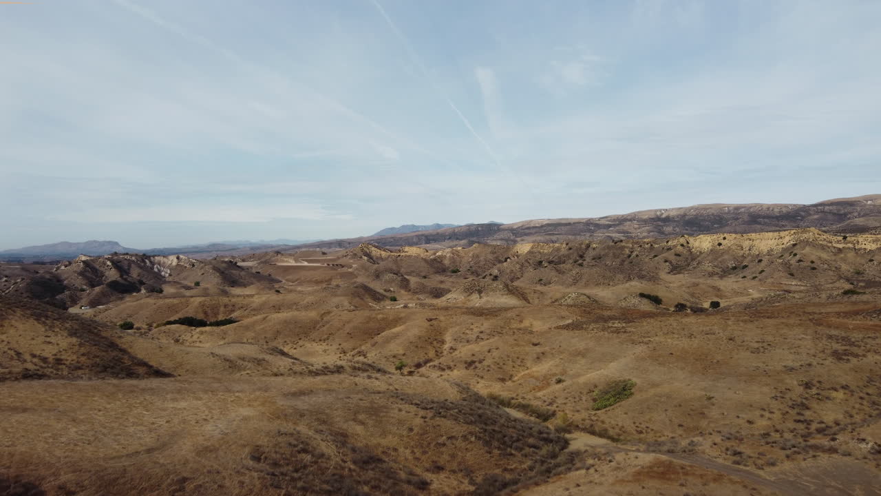Arid Hilly Landscape Under a Cloudy Sky