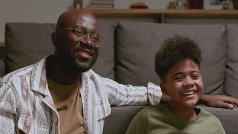 black man and boy watching tv at night
