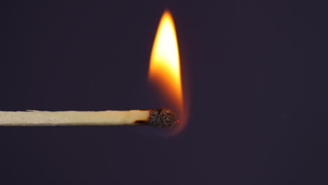 hand igniting matches close up macro shot captured from left side of black background in slow motion at 60 fps