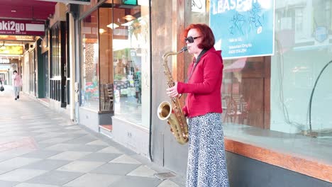 una mujer tocando el saxofón en el muelle de st kilda.