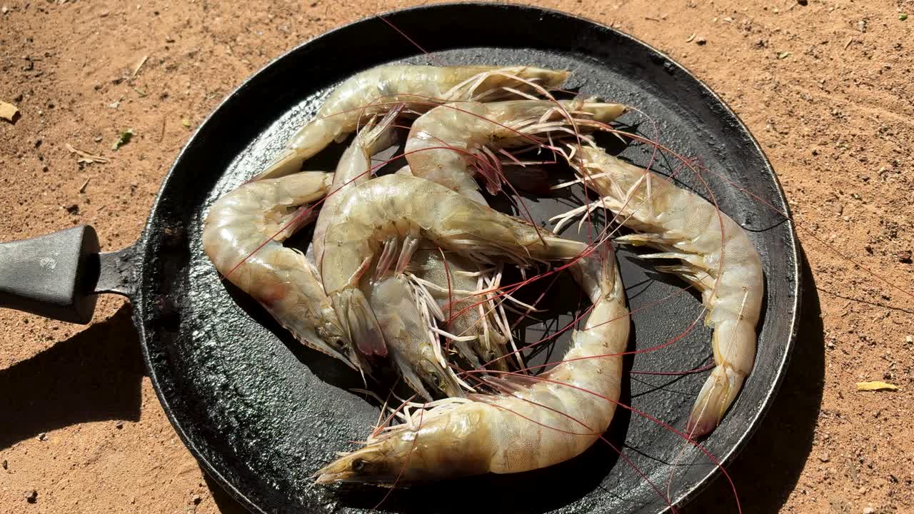 주철 팬에 담겨 야외에 놓인 생 새우