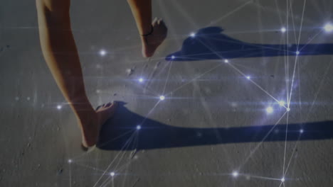 animation of glowing communication network over legs of woman walking on sandy beach