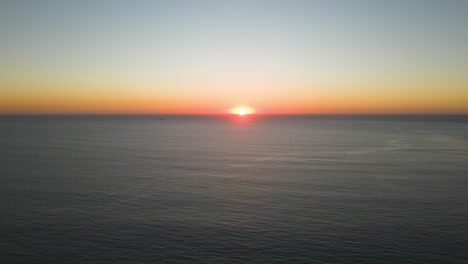 golden-and-relaxing-sunset-over-blue-ocean-with-some-boats-sailing-at-Cascais