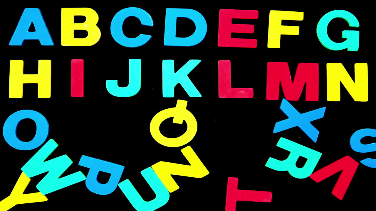 Colourful alphabet forming from pile of letters on black background