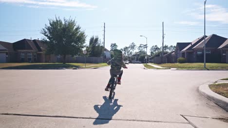 a young boy riding his bike in a neighborhood in 4k at regular speed