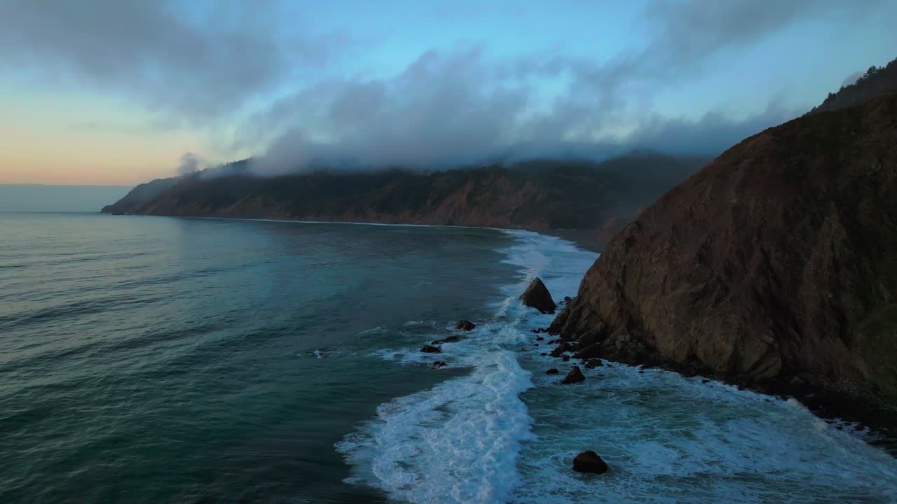 California ocean nature scene USAL Beach Campground aerial drone bluffs cliffside mist clouds mountain rocky rugged remote coast vibrant sunset Sinkyone Wilderness waves crashing surf swell static