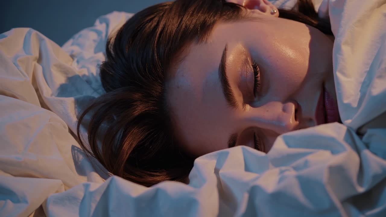 Close-up video still of a woman peacefully sleeping, captured from a side angle