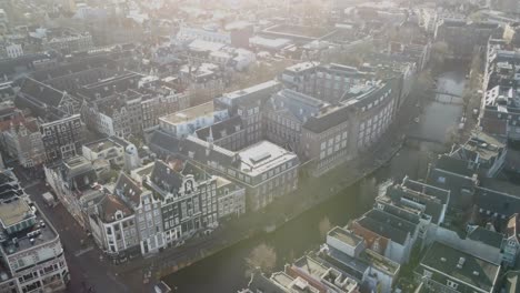 Backwards-drone-dolley-tilt-shot-over-Amsterdam-city-Centre-on-a-sunny-day