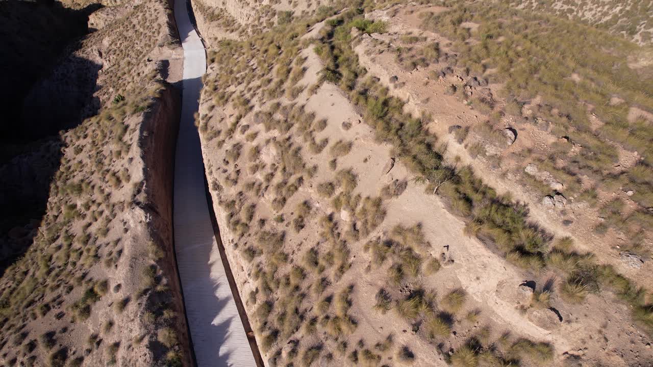 Rural road in the middle of an arid terrain. Gorafe desert in Granada, Spain