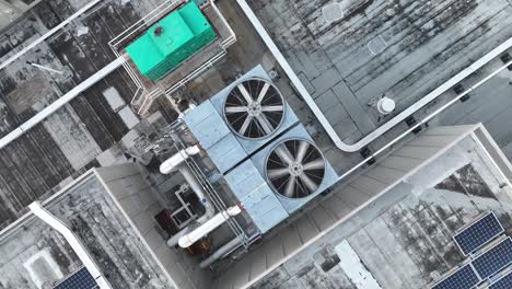 Air-conditioning-unit-fan-spinning-on-roof-of-industrial-building-in-American-city